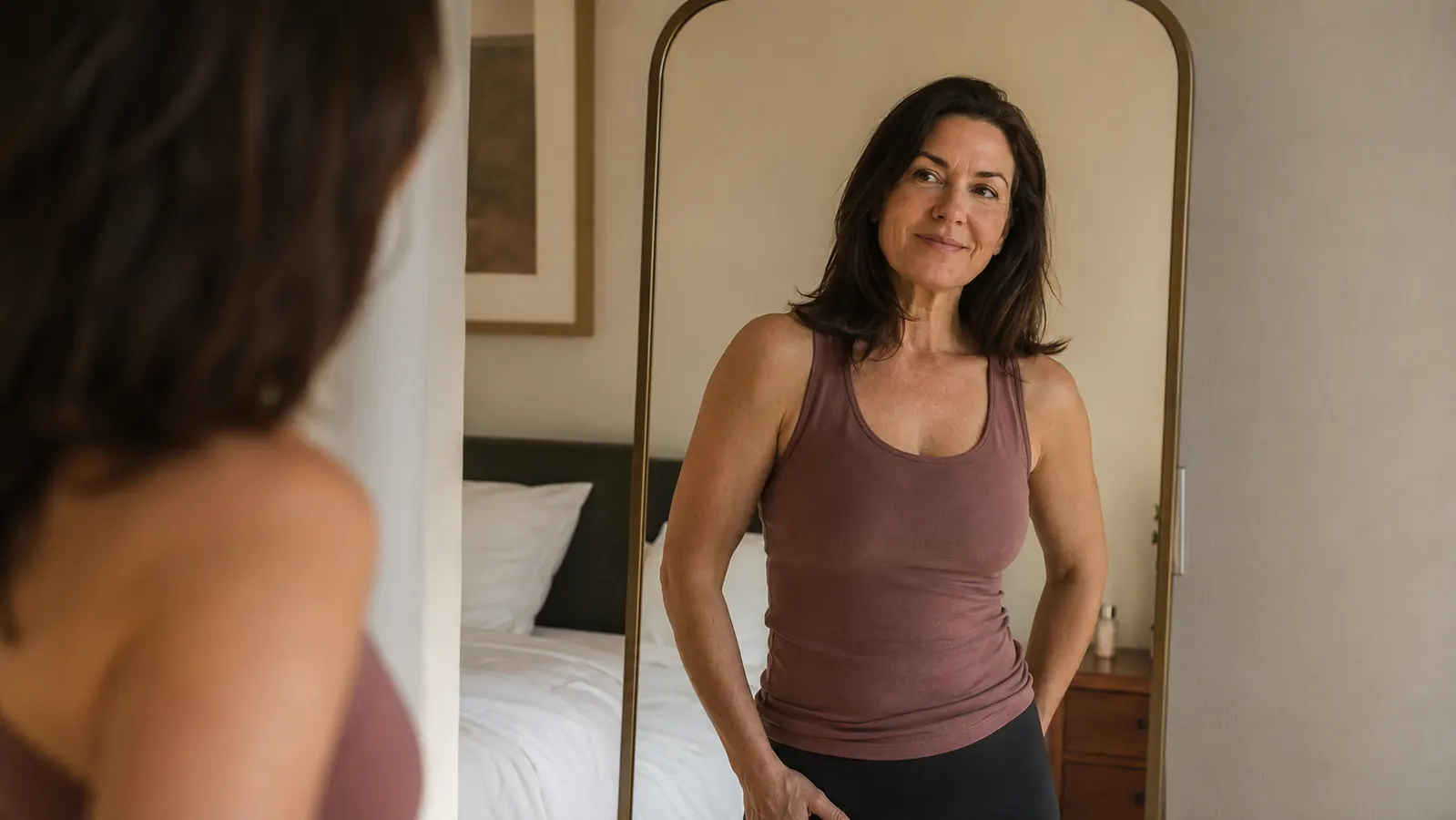 Person checking their neck alignment in a mirror after adjusting pillow loft
